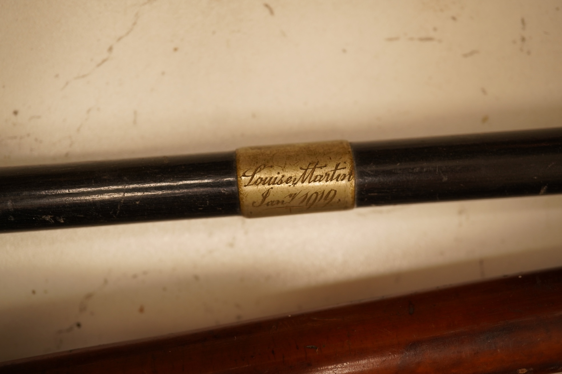 Three early 20th century antler handles riding crops with silver mounts and a swagger stick engraved Louise Martin, 1919